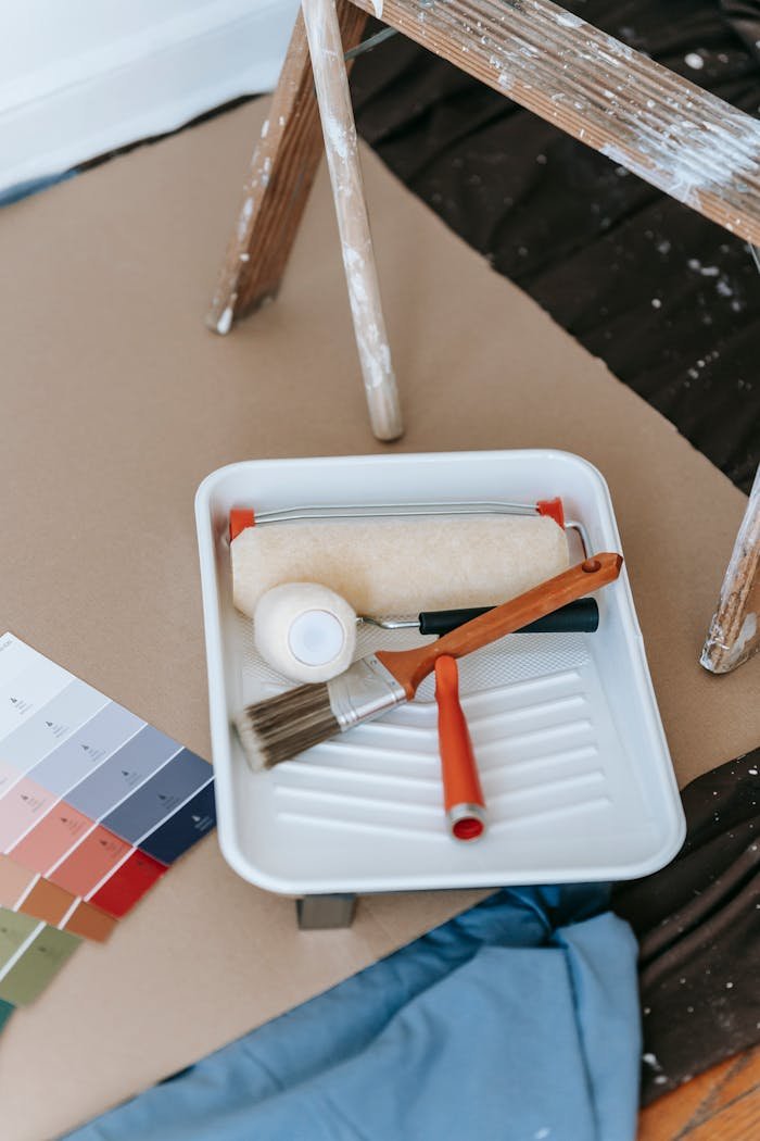 about-us A well-organized setup for a DIY home painting project, complete with tools and color swatches.